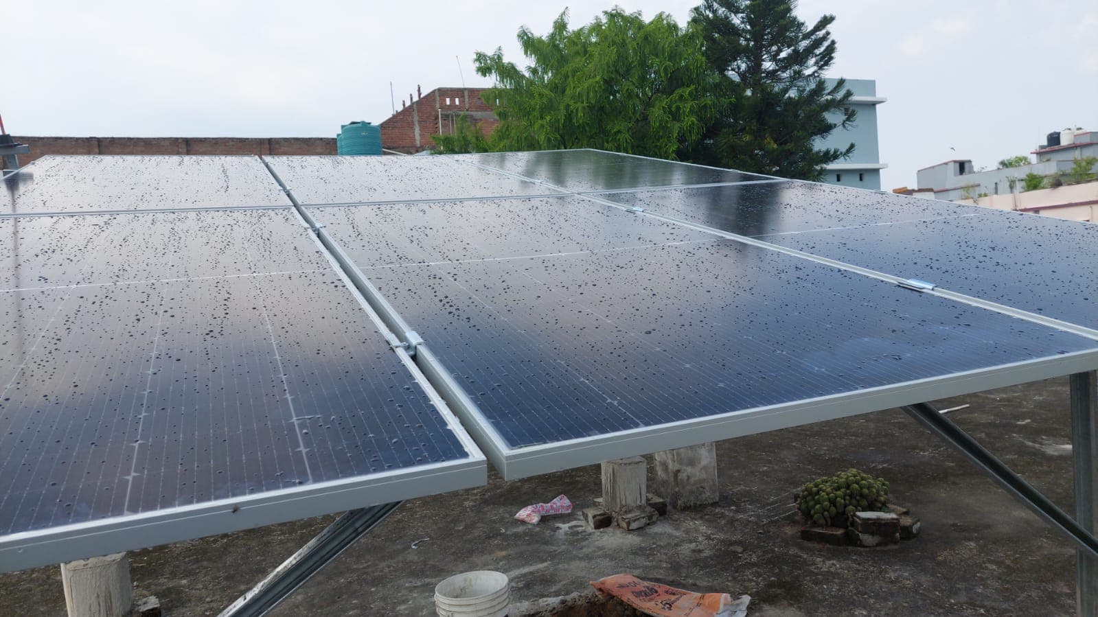 Completed residential rooftop solar panel array after rainfall.